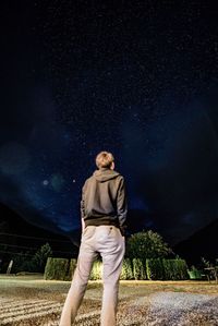 Portrait of young woman standing against star field at night