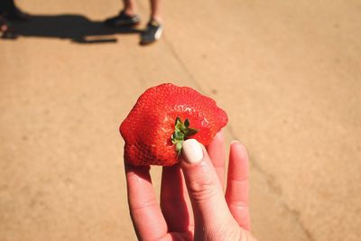 Close-up of hand holding strawberry