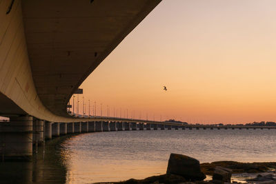 Bridge over river against sky during sunset