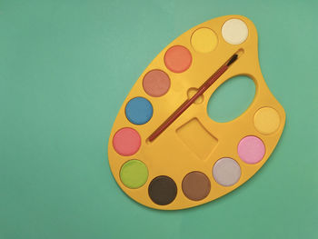 High angle view of multi colored pencils against green background