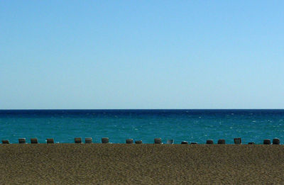 Scenic view of beach against clear blue sky