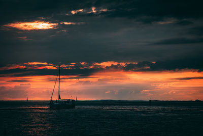 Scenic view of sea against dramatic sky during sunset