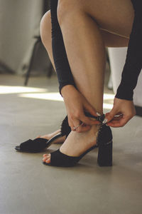Low section of woman wearing shoes on floor