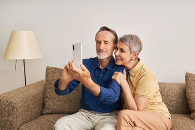 Senior couple talking on video call on smart phone at home