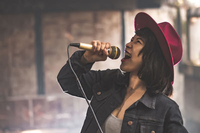 Young woman singing in microphone