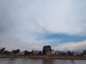 River in city against cloudy sky