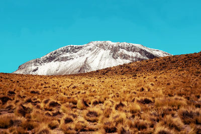 Scenic view of snowcapped mountains against clear blue sky