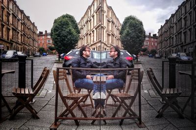 People sitting on table in city against sky