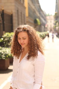 Thoughtful woman standing on footpath