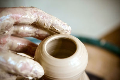 Girl sculpts in clay pot closeup. modeling clay close-up. caucasian man making vessel 