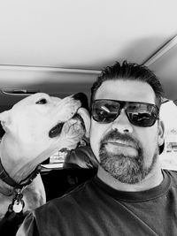 Portrait of man with dog on sunglasses