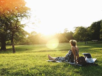 Woman sitting on field in park