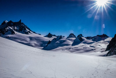 Scenic view of snowcapped mountains against blue sky