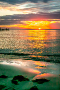 Scenic view of sea against dramatic sky during sunset