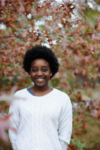 Portrait of smiling woman standing outdoors during autumn