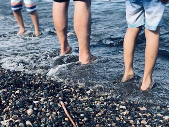 Low section of people walking on puddle