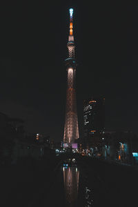 Illuminated buildings in city against sky at night