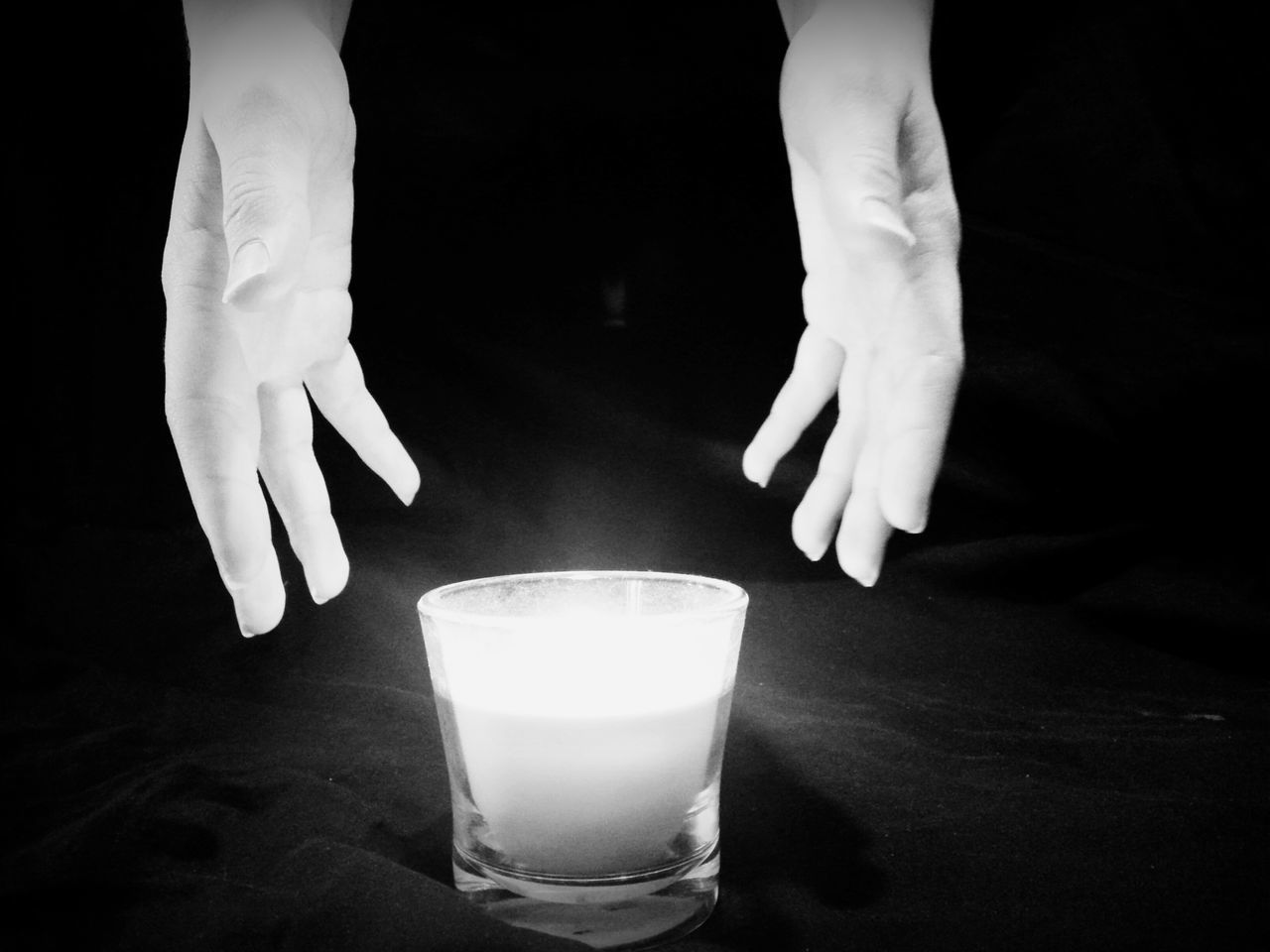 CLOSE-UP OF LIT CANDLE IN DARK ROOM