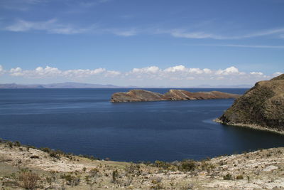 Scenic view of sea and cliff against sky