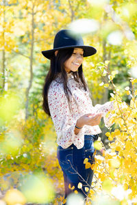 Young girl happy in a forest full of aspen trees during fall