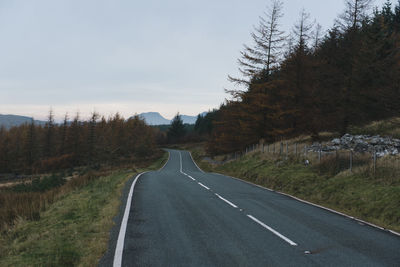 Road amidst trees against sky