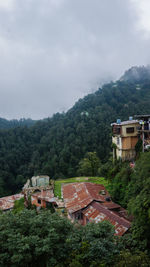 Houses by trees and mountains against sky