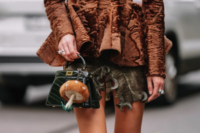 Low section of woman standing against wall