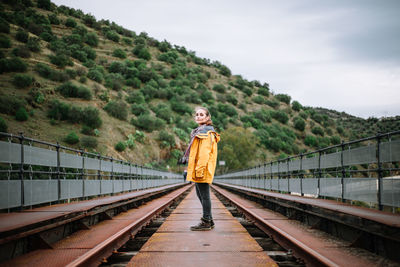 Rear view of woman standing on footbridge