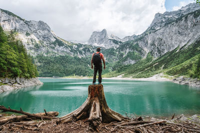 Woman looking at lake against mountain range