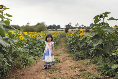 Full length portrait of girl standing on field