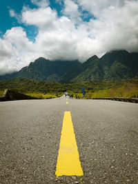 Road by mountains against sky