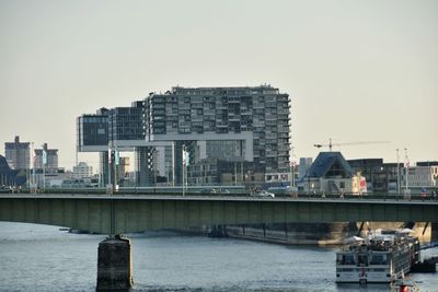 Bridge over river in city against clear sky