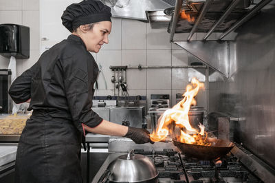 Side view of man preparing food in kitchen