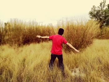 Rear view of boys walking on dirt road