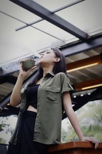 Low angle view of young woman looking away