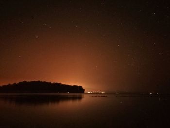 Scenic view of lake against sky at night