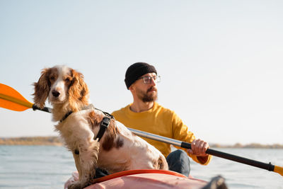 Man sitting in kayak with dog in sea