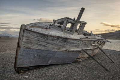 Abandoned ship on beach against sky