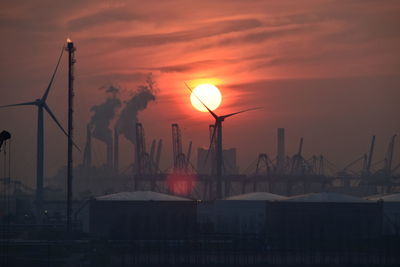 View of silhouette wind turbine at sunset