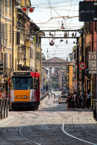 Cars on street in city against sky