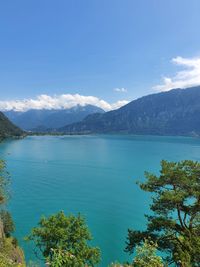 Scenic view of lake and mountains against blue sky