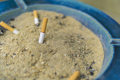 Close-up of cigarettes in sand