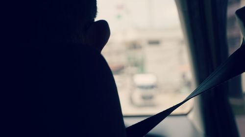 Rear view of silhouette woman in car