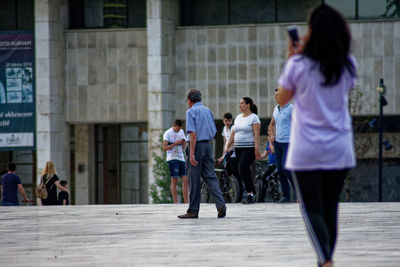 Rear view of people walking on street