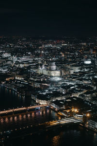 High angle view of illuminated city by river at night