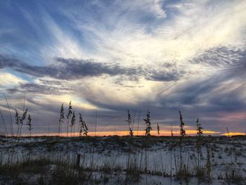 Silhouette of electricity pylon against sky during sunset