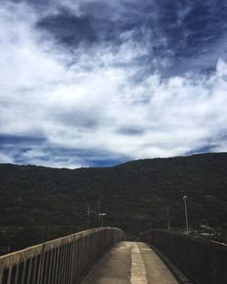 Road by bridge against sky