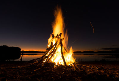 Bonfire on beach against sky at night
