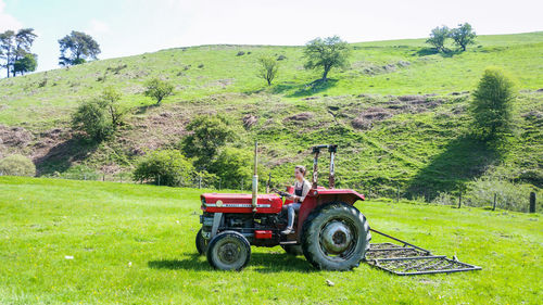 Tractor on agricultural landscape against sky