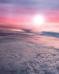 Technicolor sky during sunrise over an ocean of clouds seen from above -- on a plane.
